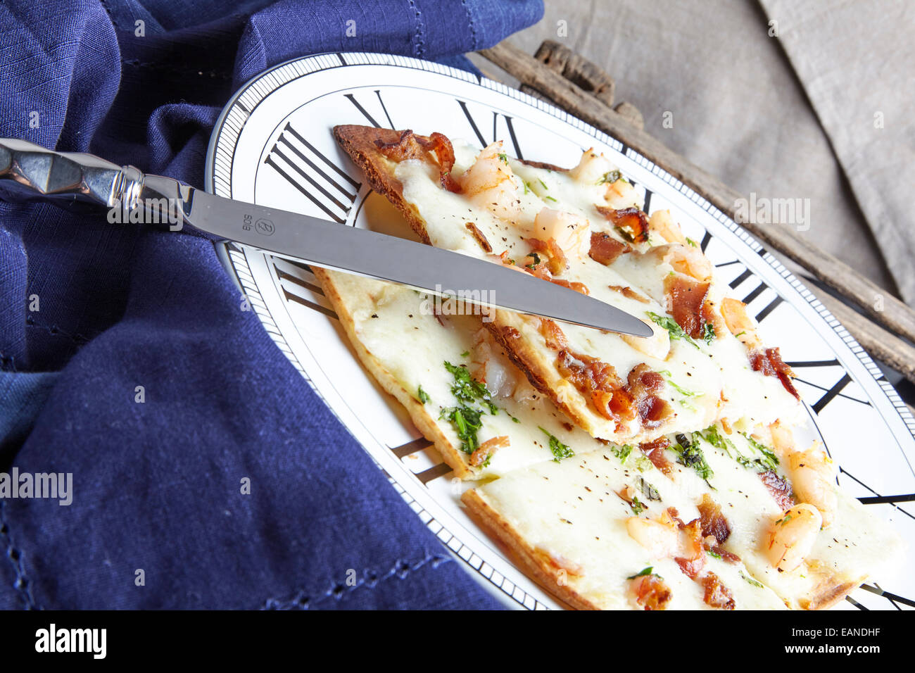 Shrimp flatbread with cilantro white cheddar Parmesan bacon with navy napkin Stock Photo