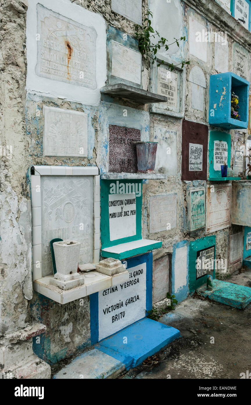 Colorful stacked graves with hand painted and carved grave markers, and grave offerings in the Champoton Cemetery, Mexico. Stock Photo