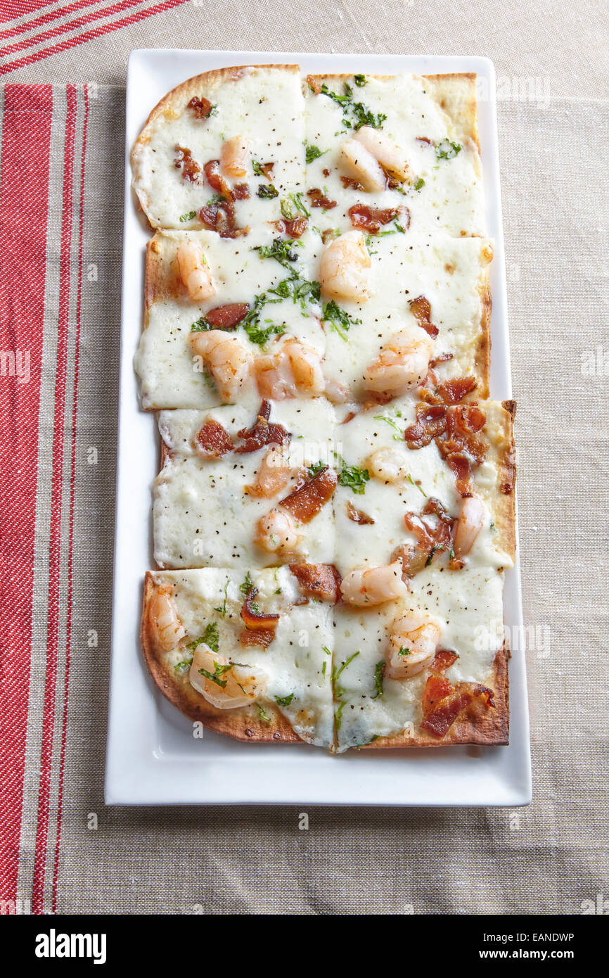 Shrimp flatbread with cilantro white cheddar Parmesan bacon with red stripe napkin Stock Photo