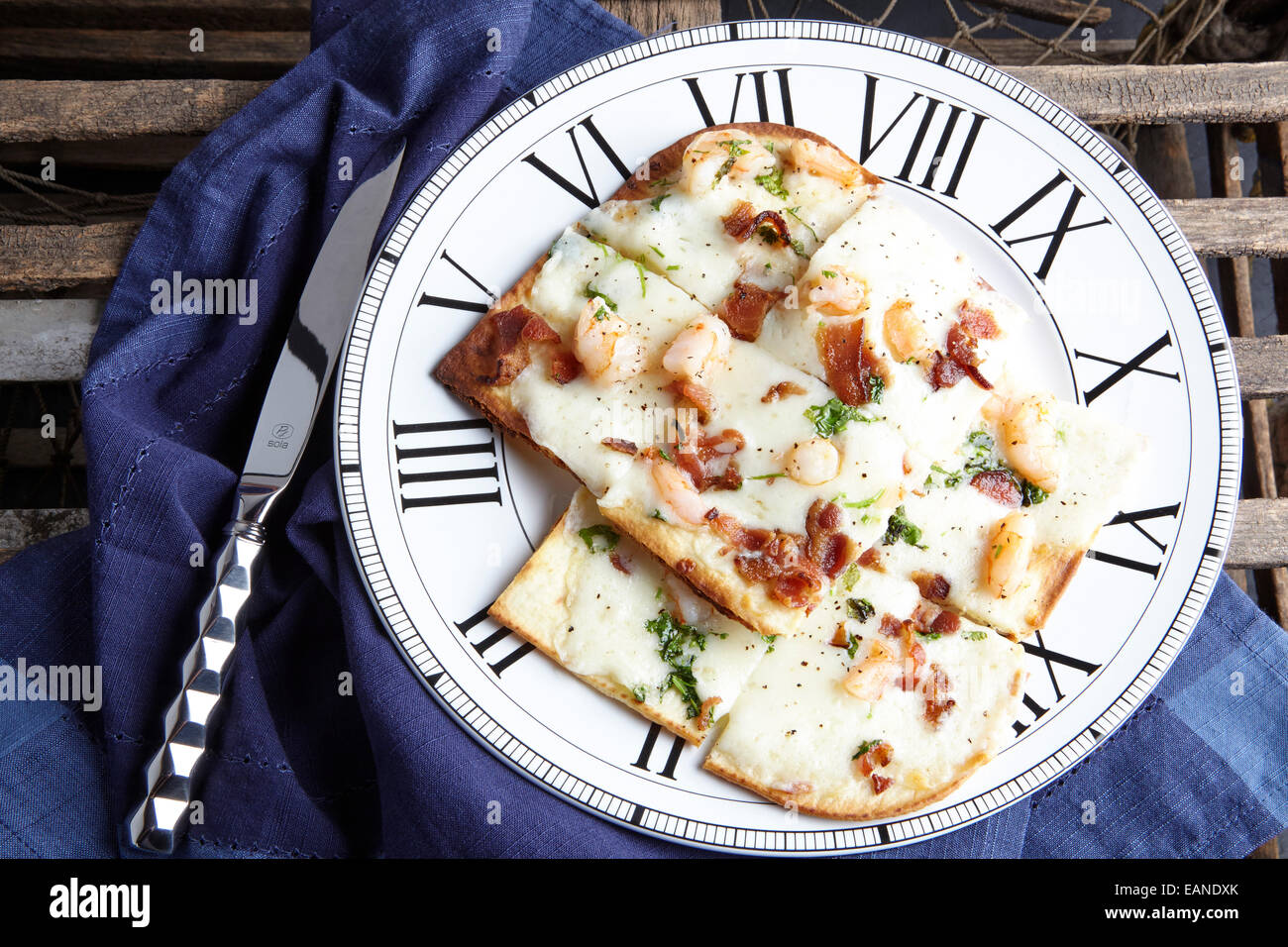 Shrimp flatbread with cilantro white cheddar Parmesan bacon with navy napkin Stock Photo
