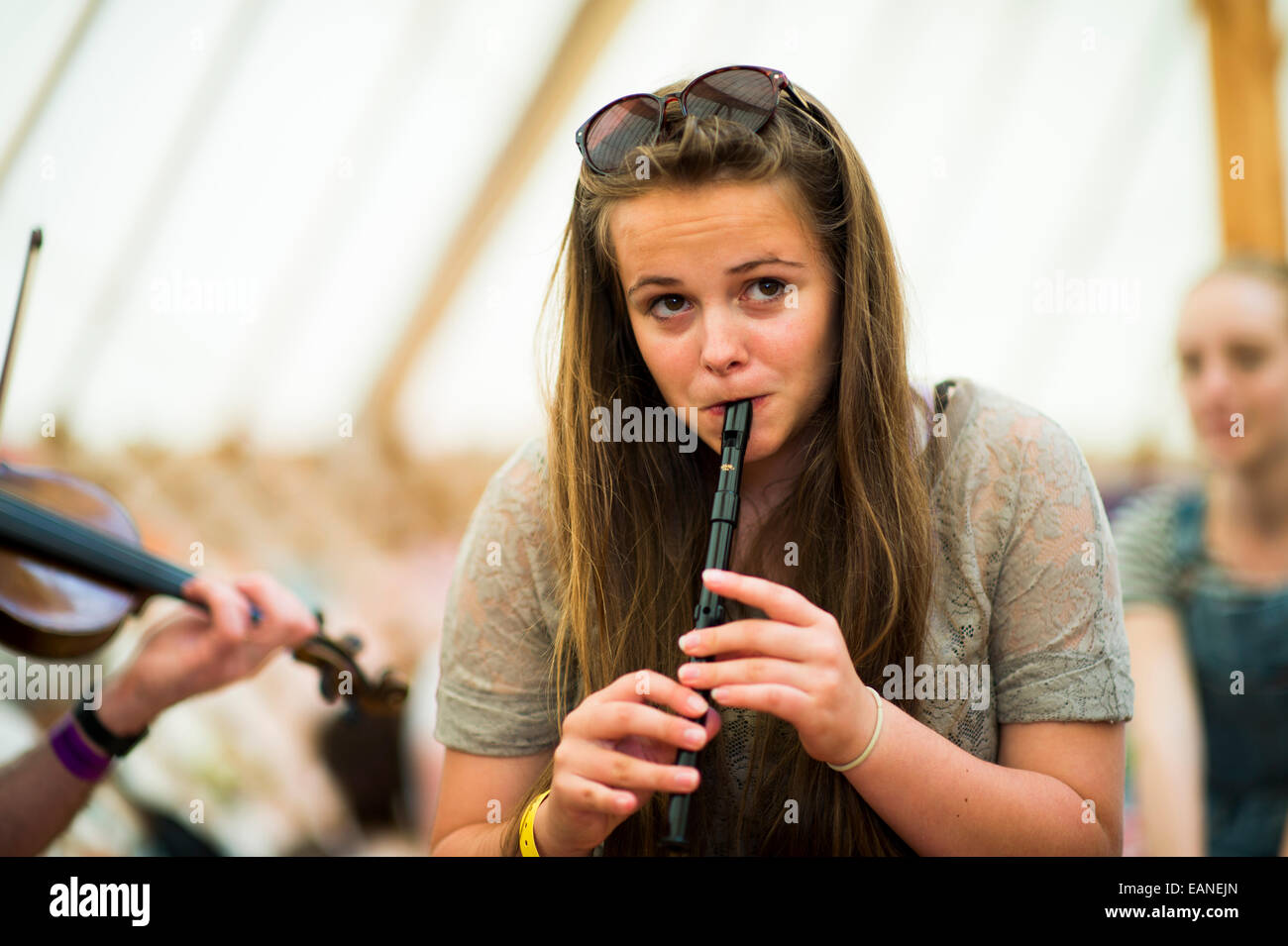A young teenage girl playing traditional folk music on the tin recorder whistle  at the National Eisteddfod of Wales, 2014 Stock Photo