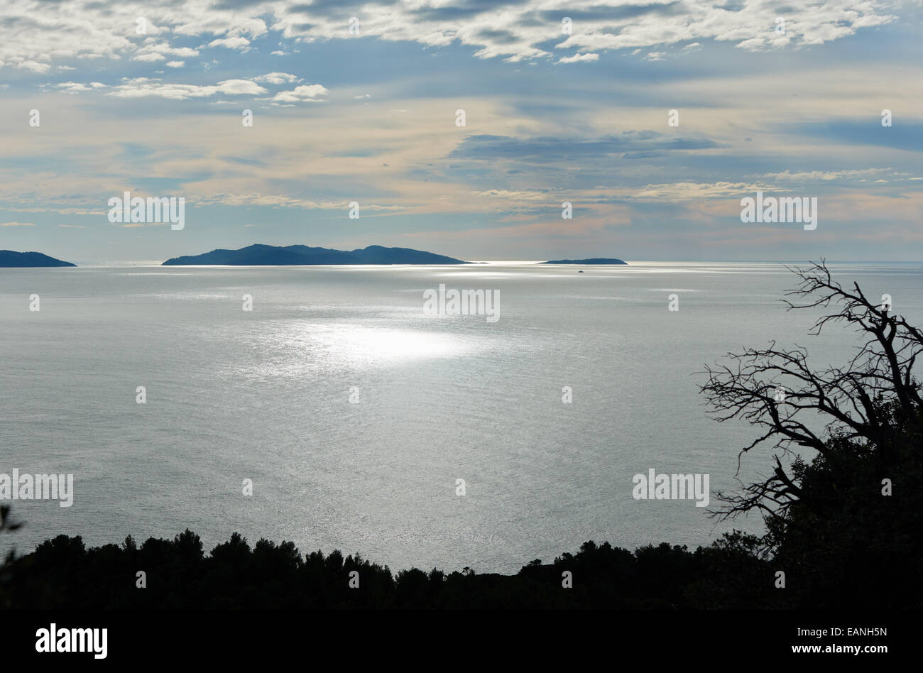 Seascape with little island in calm Mediterranean sea water on background of sky with beautiful clouds Stock Photo