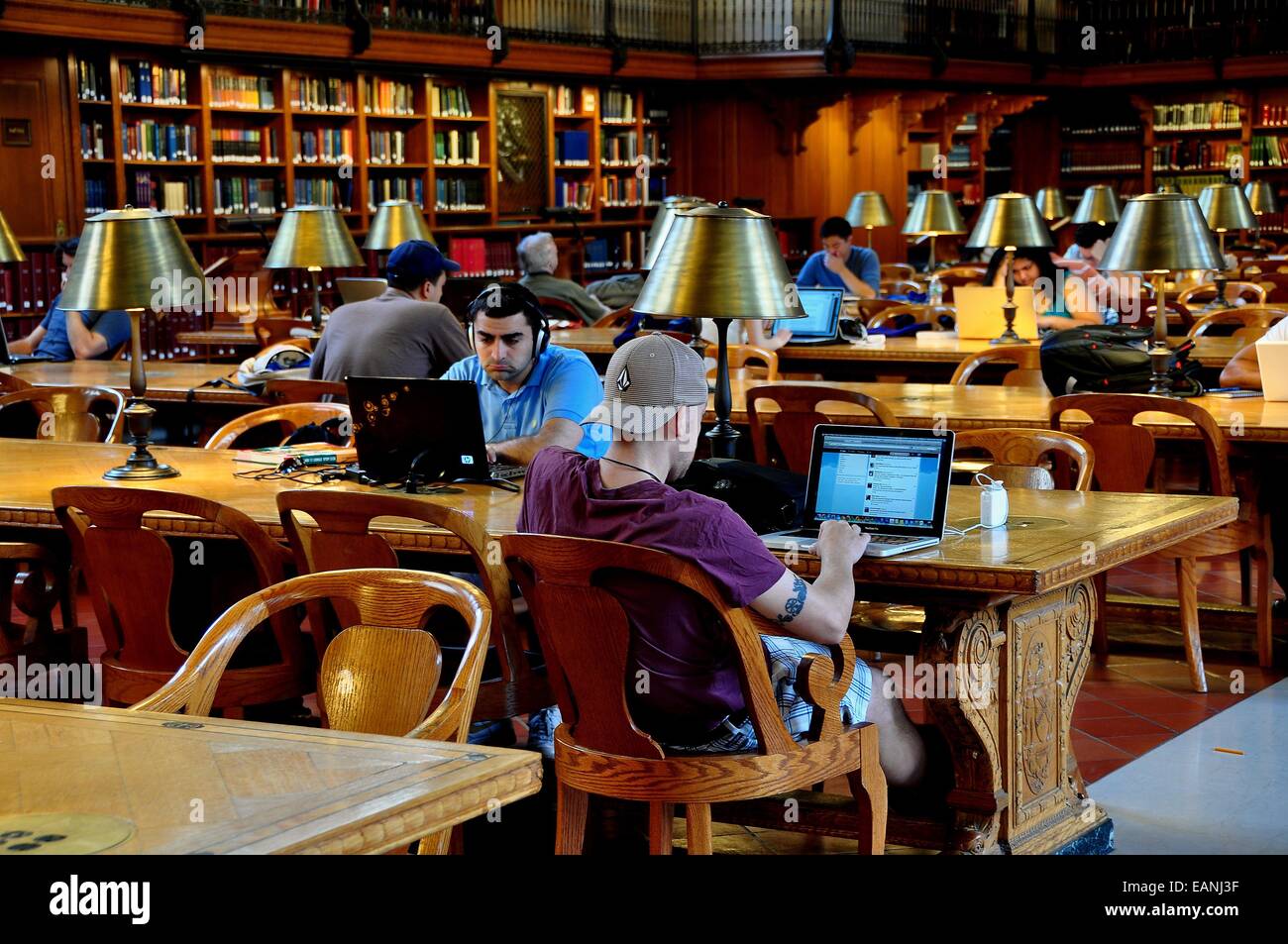 NYC People seated at long wooden tables using computers in main
