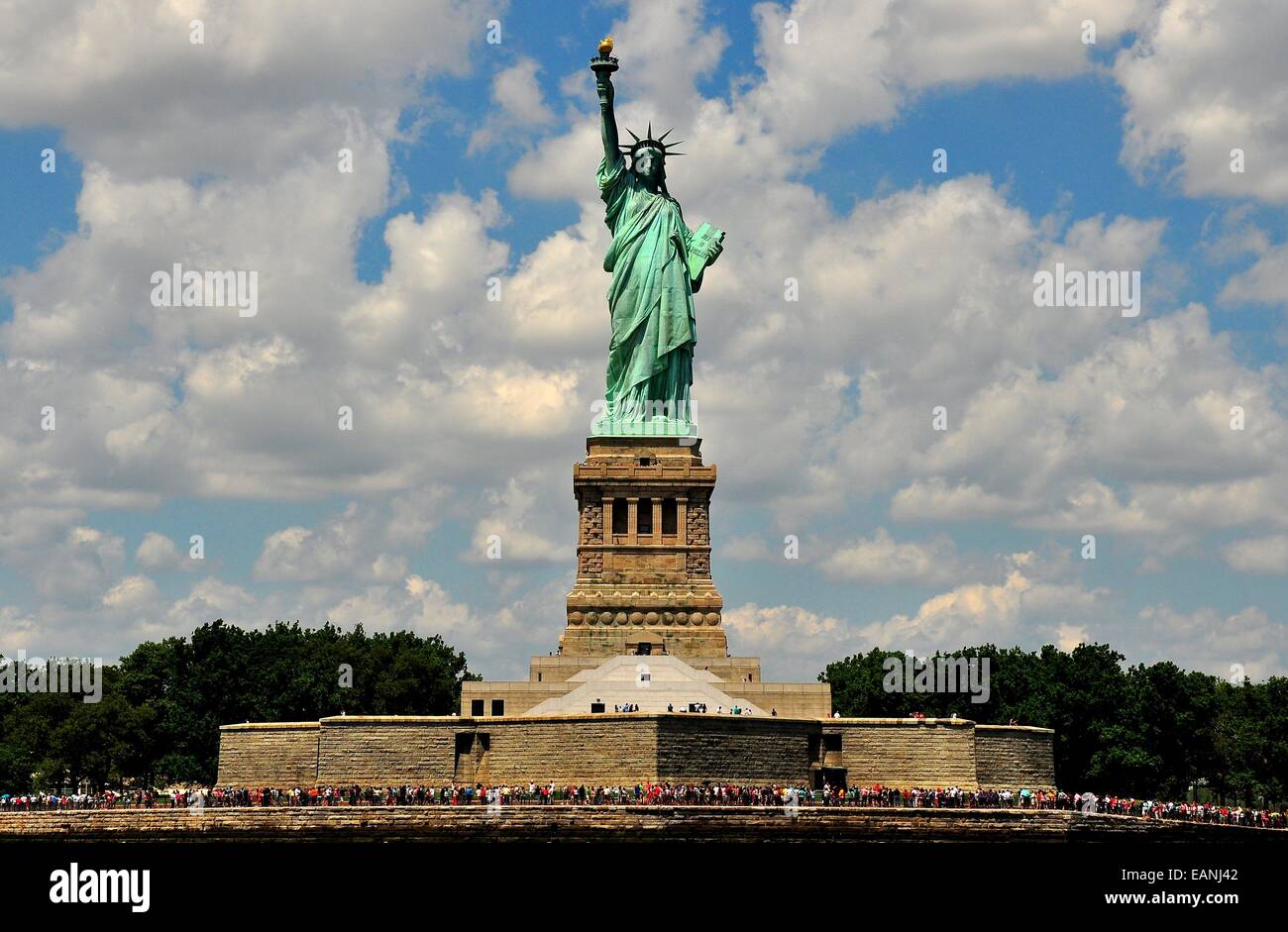 NYC The Statue of Liberty sitting above its base with crowds of tourists visiting the island on