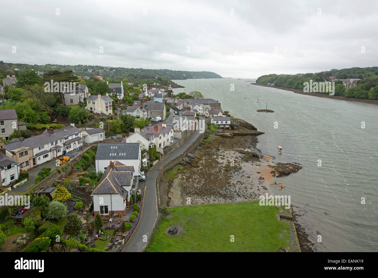 View, from high suspension bridge over wide Menai Strait, of town of Beaumaris on Isle of Anglesey & coast of Welsh mainland Stock Photo