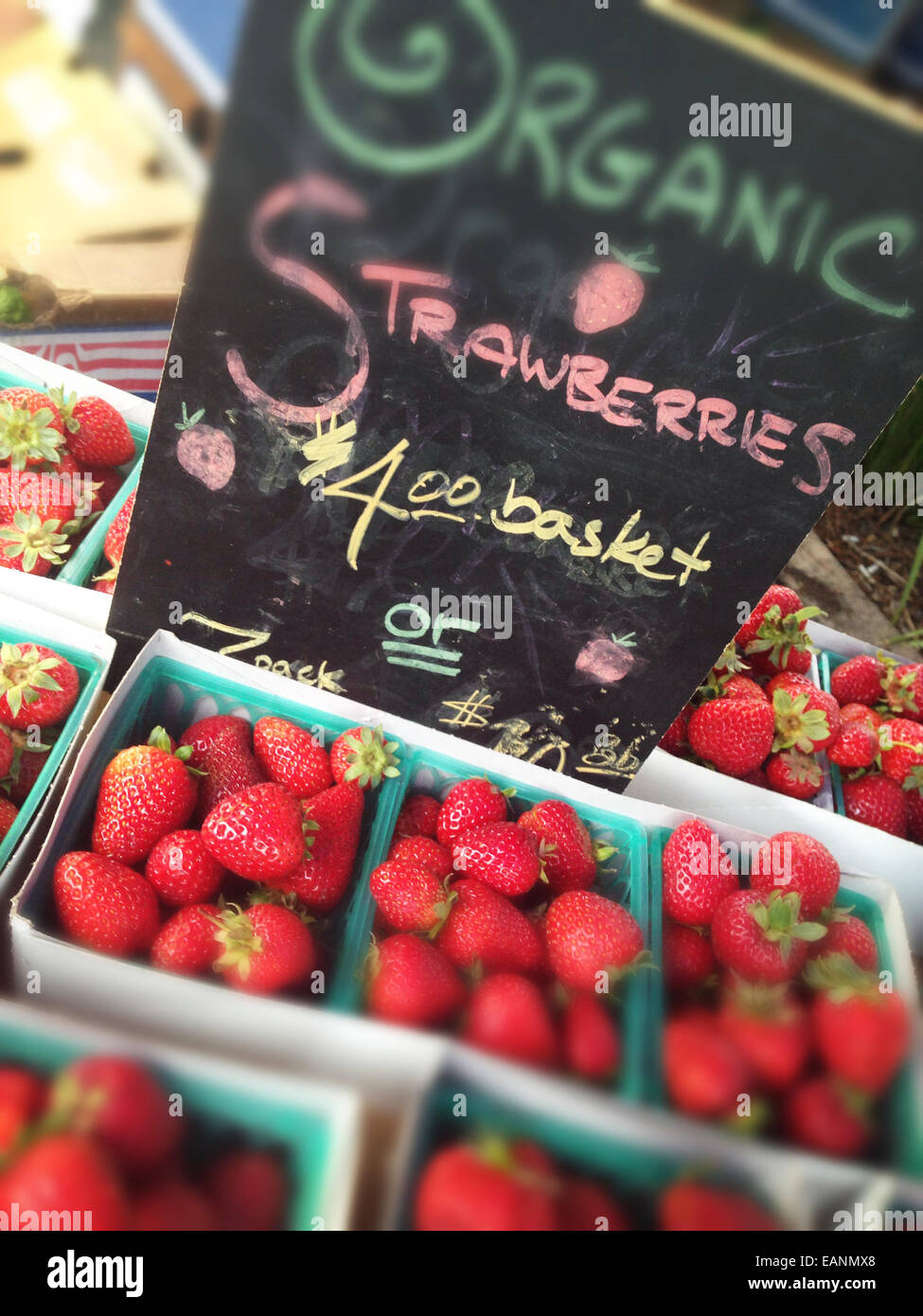 Organic Strawberries in a basket at a farm stand Stock Photo