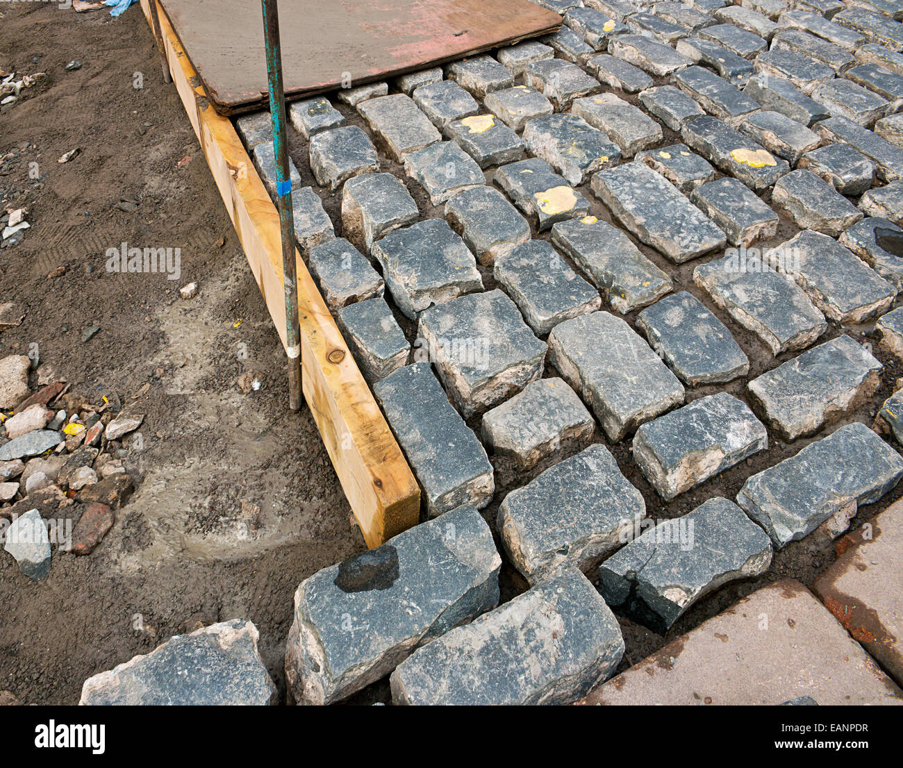 Traditional cobblestone drive being laid by hand by a skilled craftsmen in the construction industry. Stock Photo