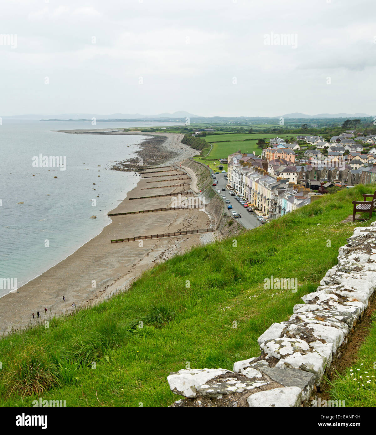 View, from hilltop castle, of historic Welsh town of Criccieth with row of houses by sandy beach of Cardigan Bay & green fields Stock Photo