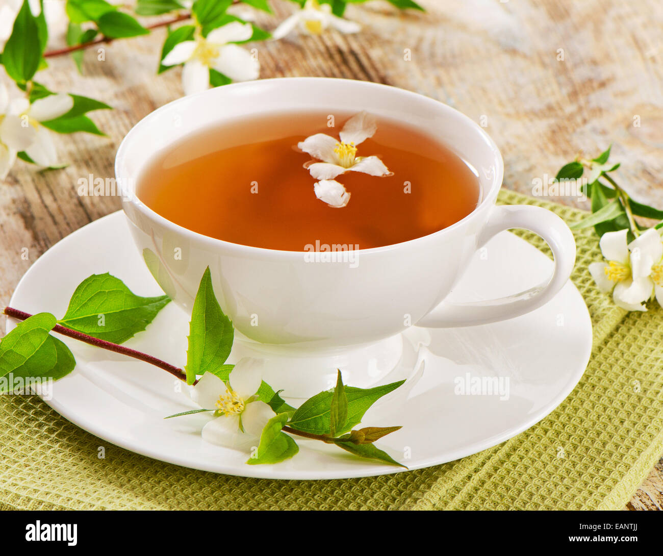 Jasmine tea in a white cup with flowers . Selective focus Stock Photo