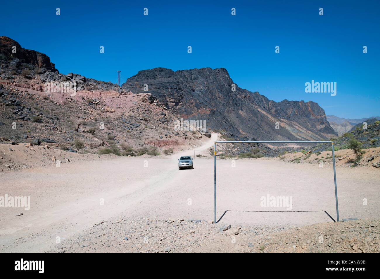 Local Omani village soccer field built across a road - the only flat location. Stock Photo