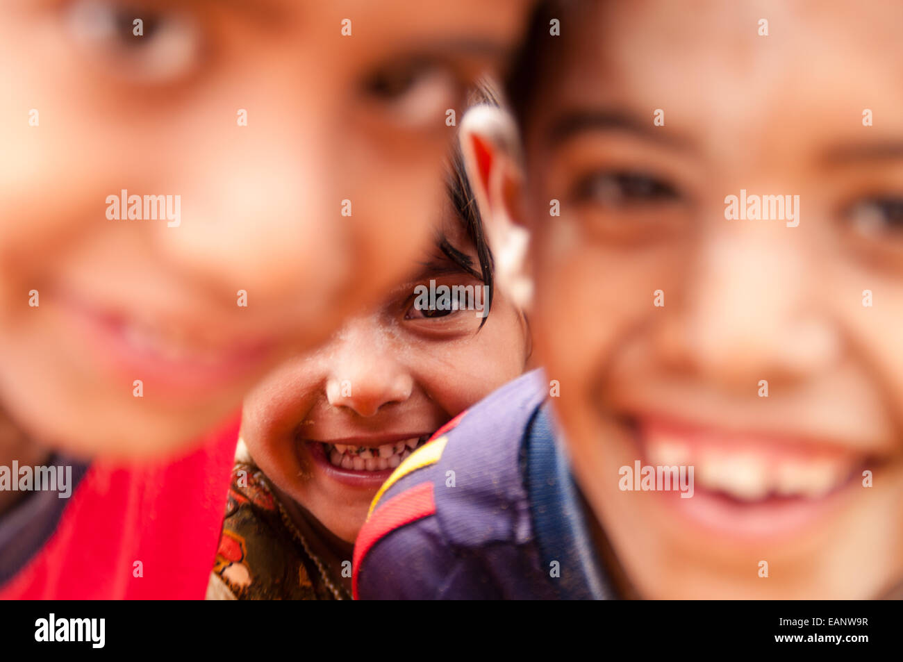 Omani local children having fun with mud smeared on their faces while enjoying flow in the wadi after a rare rainfall event Stock Photo