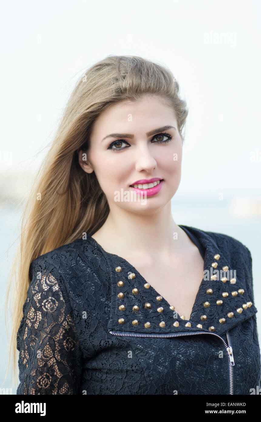 Beautiful young woman smiling outdoors Stock Photo - Alamy