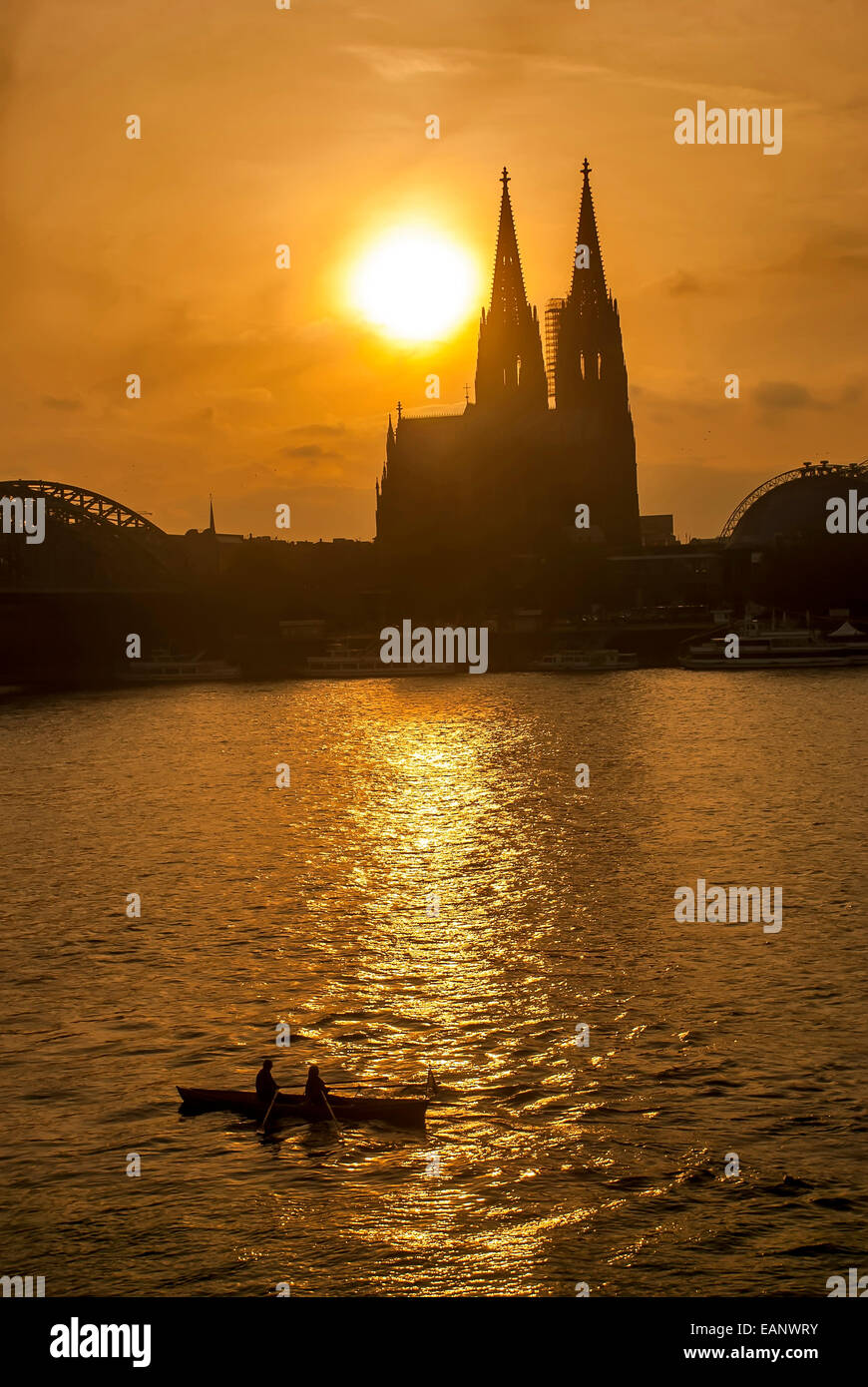 Duas pessoas passeando em barco a remo no rio Reno assistindo o pôr do sol atrás da Catedral de Colônia. / Two persons enjoying Stock Photo