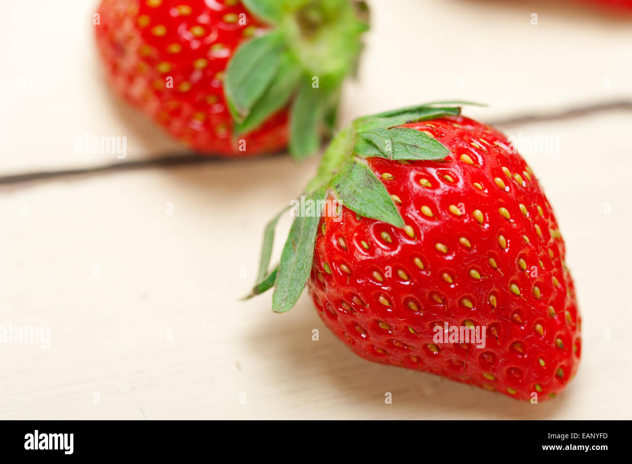 fresh organic strawberry over white rustic wood table Stock Photo - Alamy