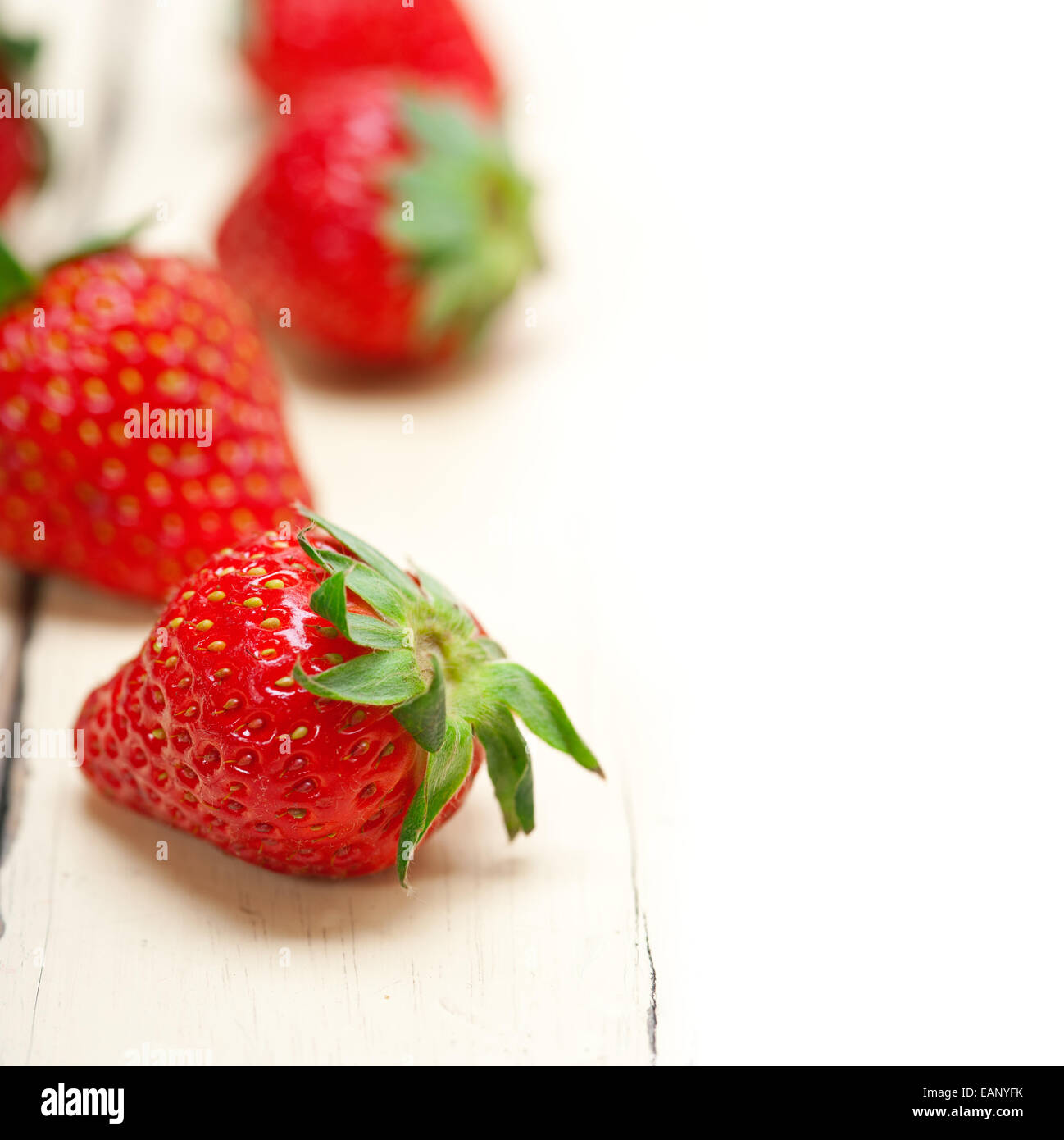 fresh organic strawberry over white rustic wood table Stock Photo - Alamy