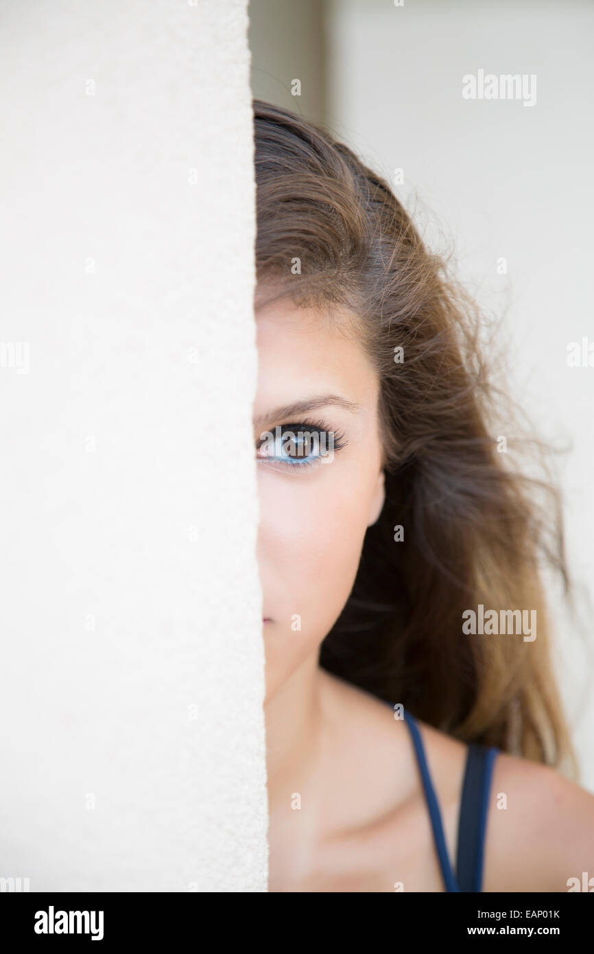 Young woman hiding behind wall Stock Photo Alamy