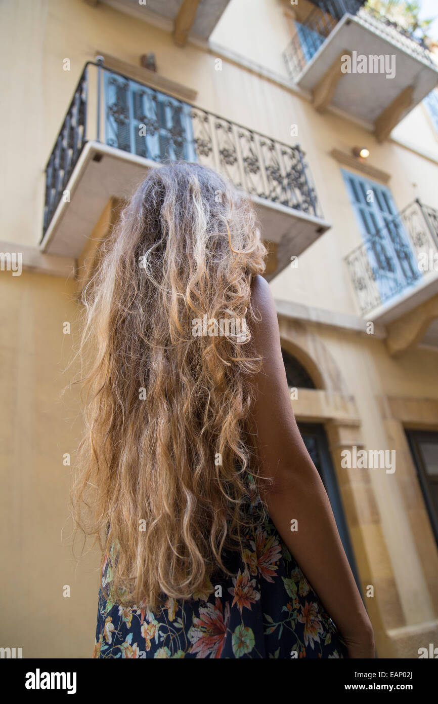 Woman with long dark hair walking in the street Stock Photo - Alamy