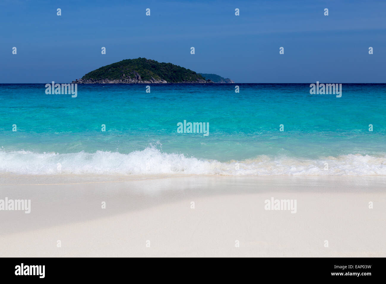 White sand beach and turquoise blue sea under a blue sky. Stock Photo