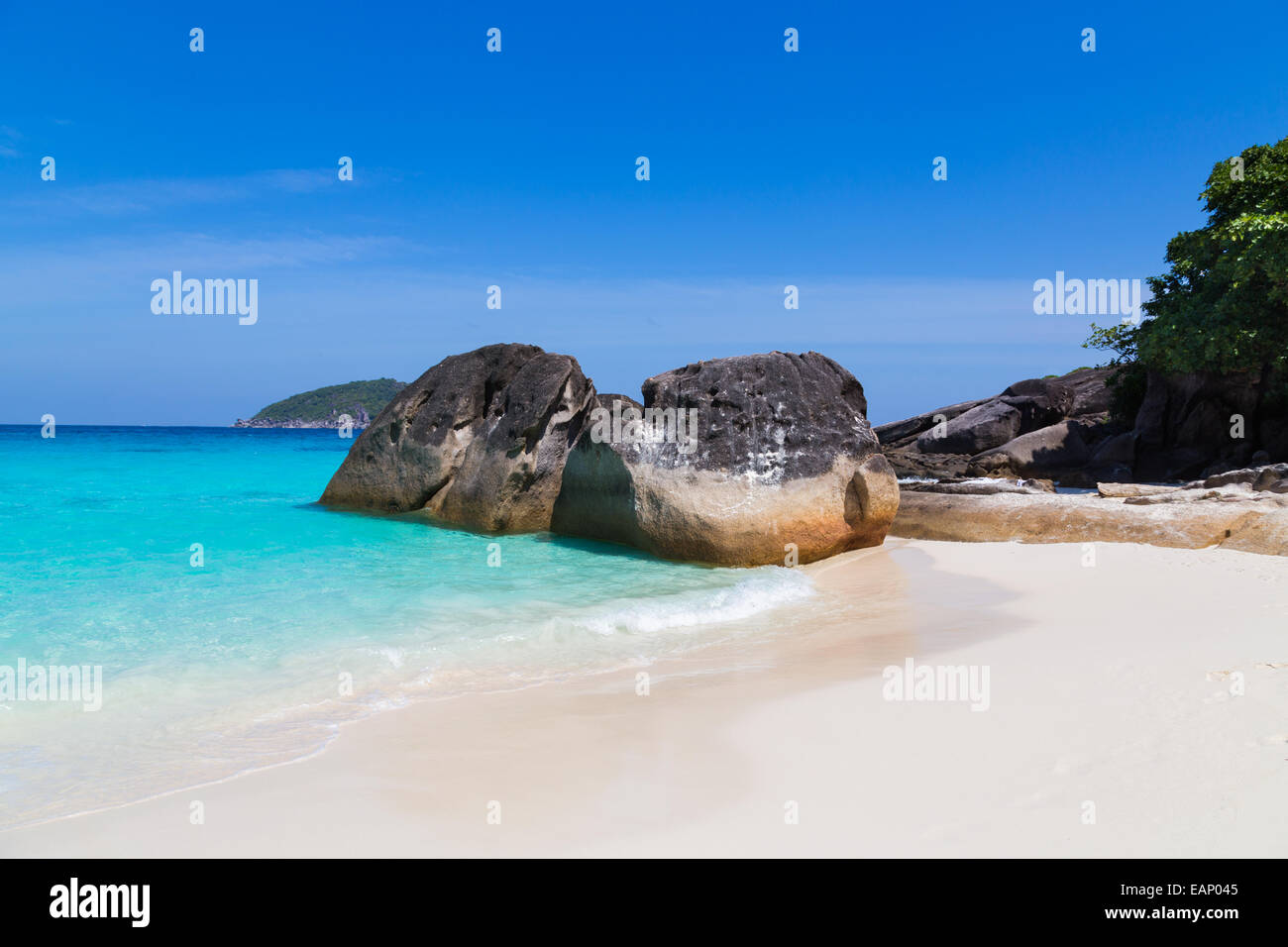 White sand beach and turquoise blue sea under a blue sky. Stock Photo