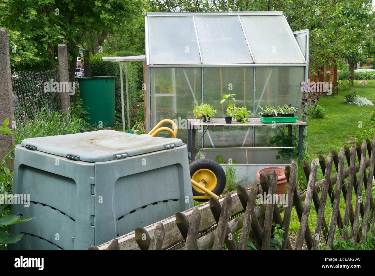 Greenhouse with work table and plastic compost bin Stock Photo Alamy