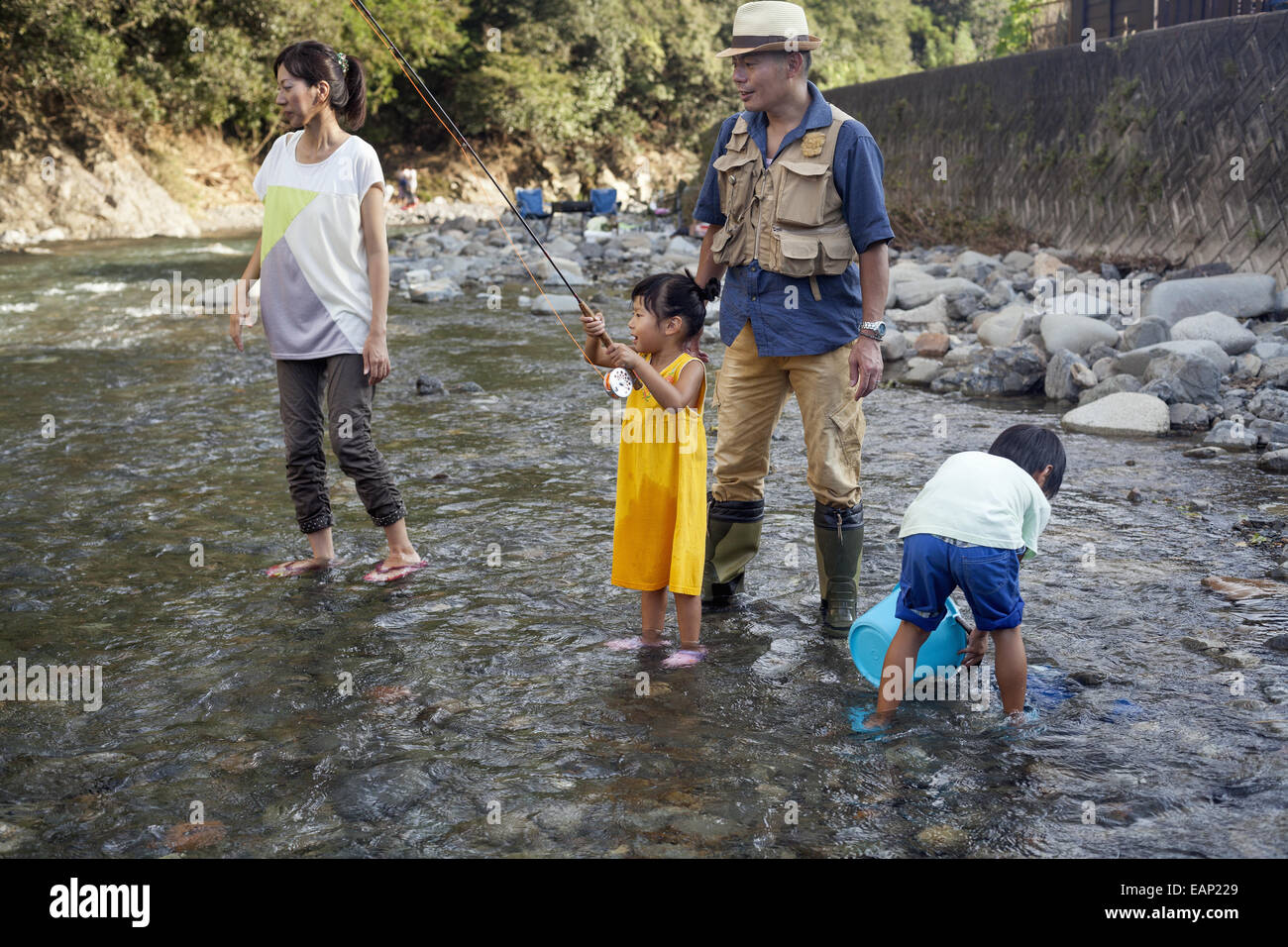 Family fishing in a stream. Stock Photo