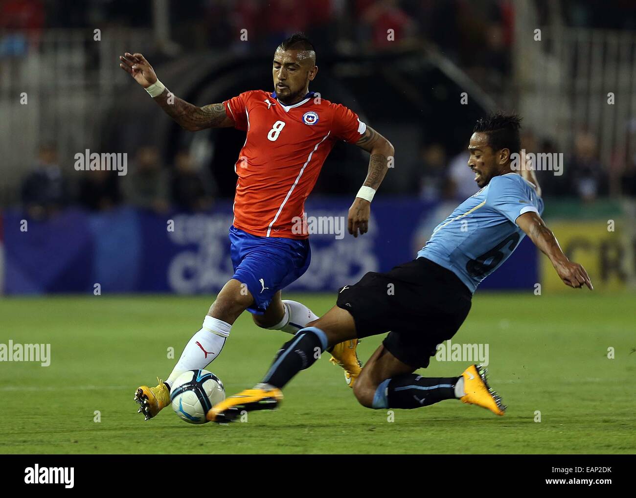 Santiago, Chile. 18th Nov, 2014. Image provided by National Association of Professional Soccer (ANFP, for its acronym in Spanish) of Chile shows Chile's Arturo Vidal (L) vying with Alvaro Pereira (R) of Uruguay during a friendly match at Monumental Stadium, in Santiago, Chile, on Nov. 18, 2014. © ANFP/Xinhua/Alamy Live News Stock Photo