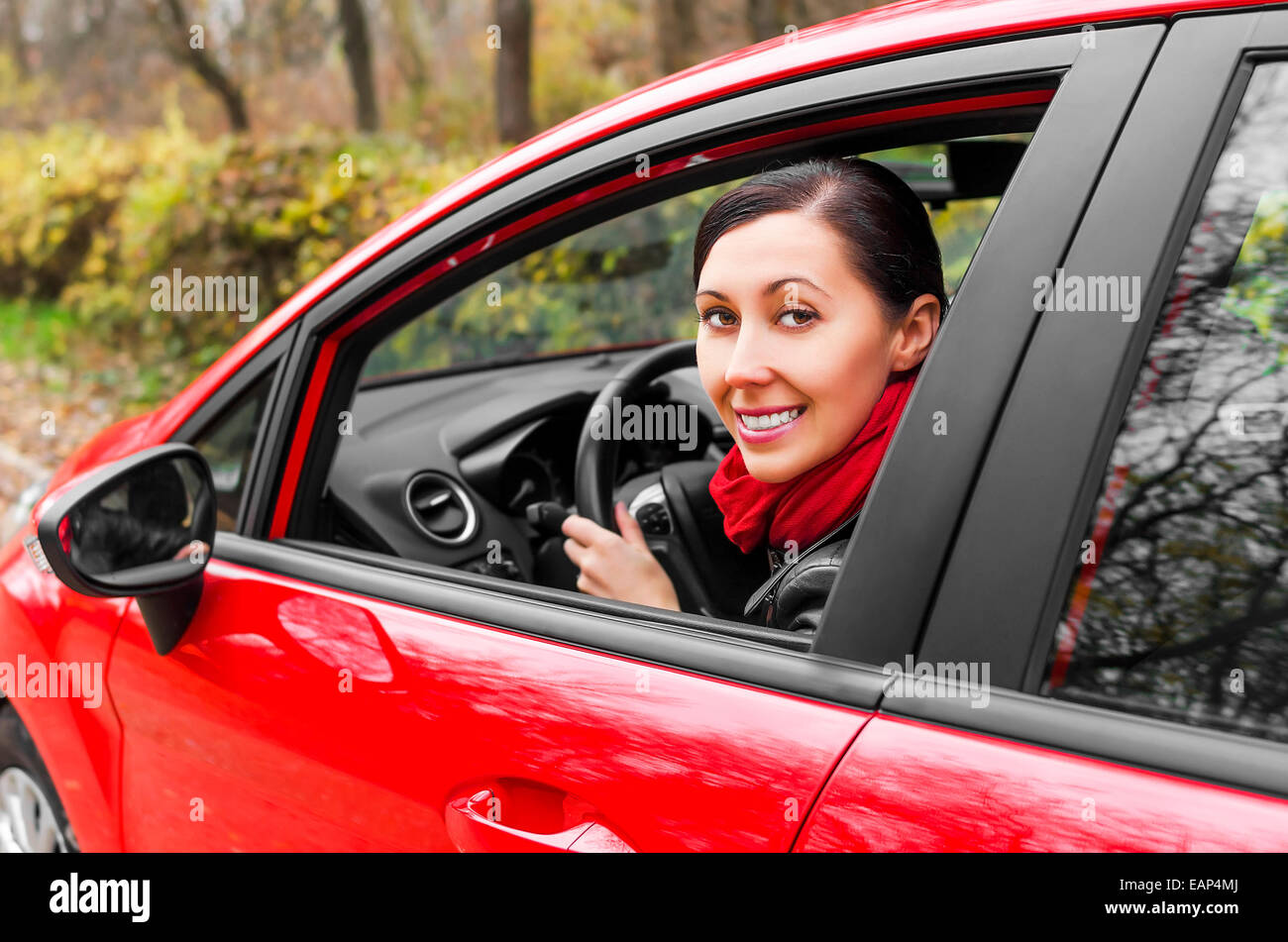 Driver smiling girl in a red car Stock Photo - Alamy