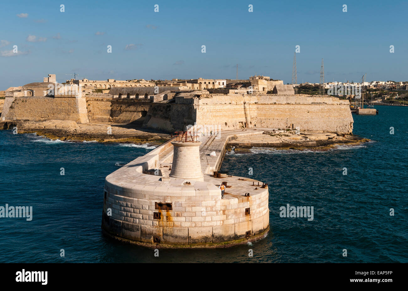 Valletta, Malta - entrance to the Grand Harbour. The Ricasoli lighthouse and breakwater with Fort Ricasoli (Forti Ricazoli) Stock Photo
