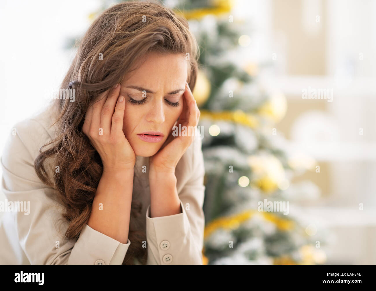 Portrait of stressed young woman near christmas tree Stock Photo