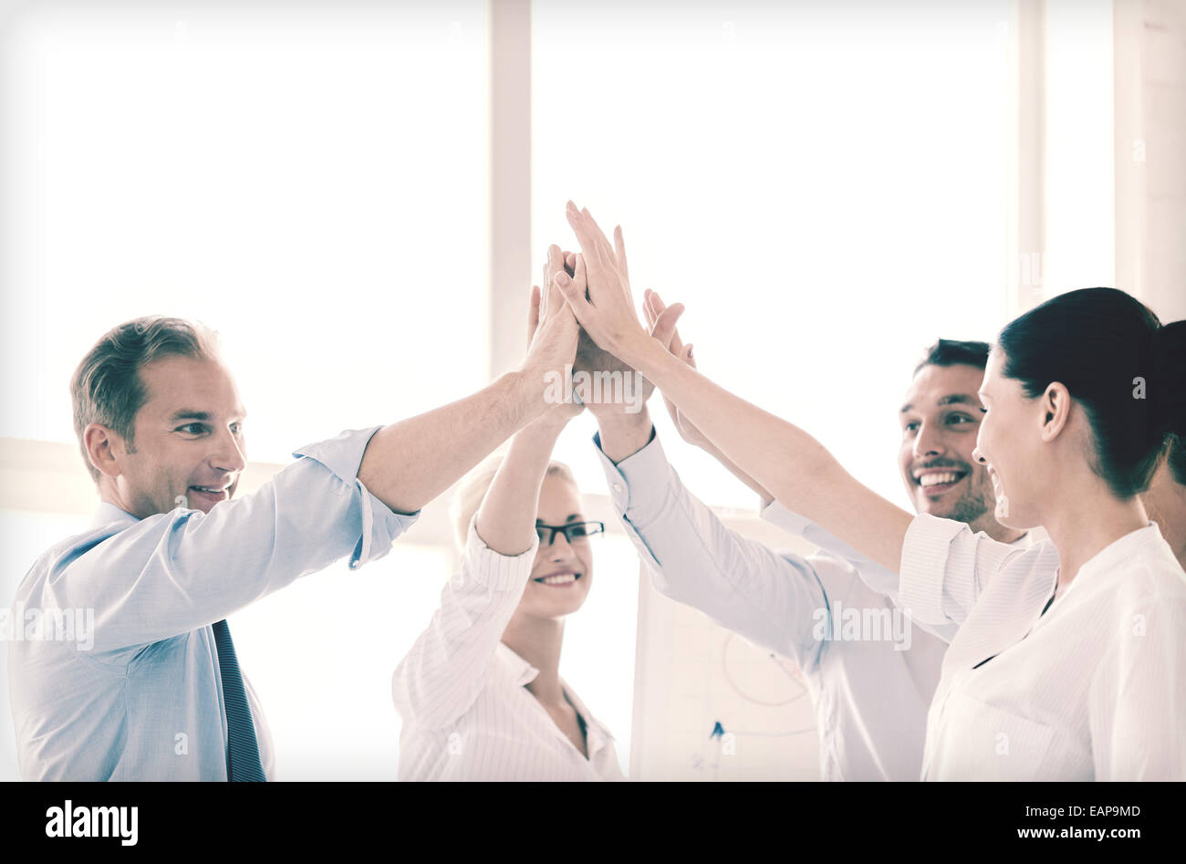 happy business team giving high five in office Stock Photo - Alamy