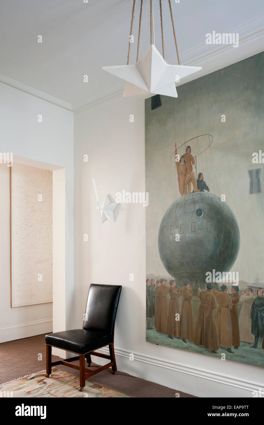 Copy of Russian painting 'Red Army Manouvre' in hallway with leather chair and star shaped ceiling light Stock Photo