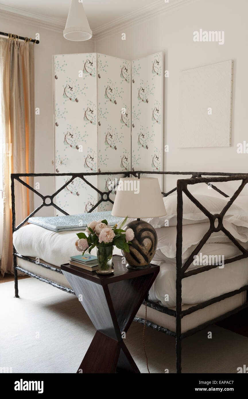 Marie Laurencin wallpaper covered screen in bedroom with hour glass style bedside table Stock Photo