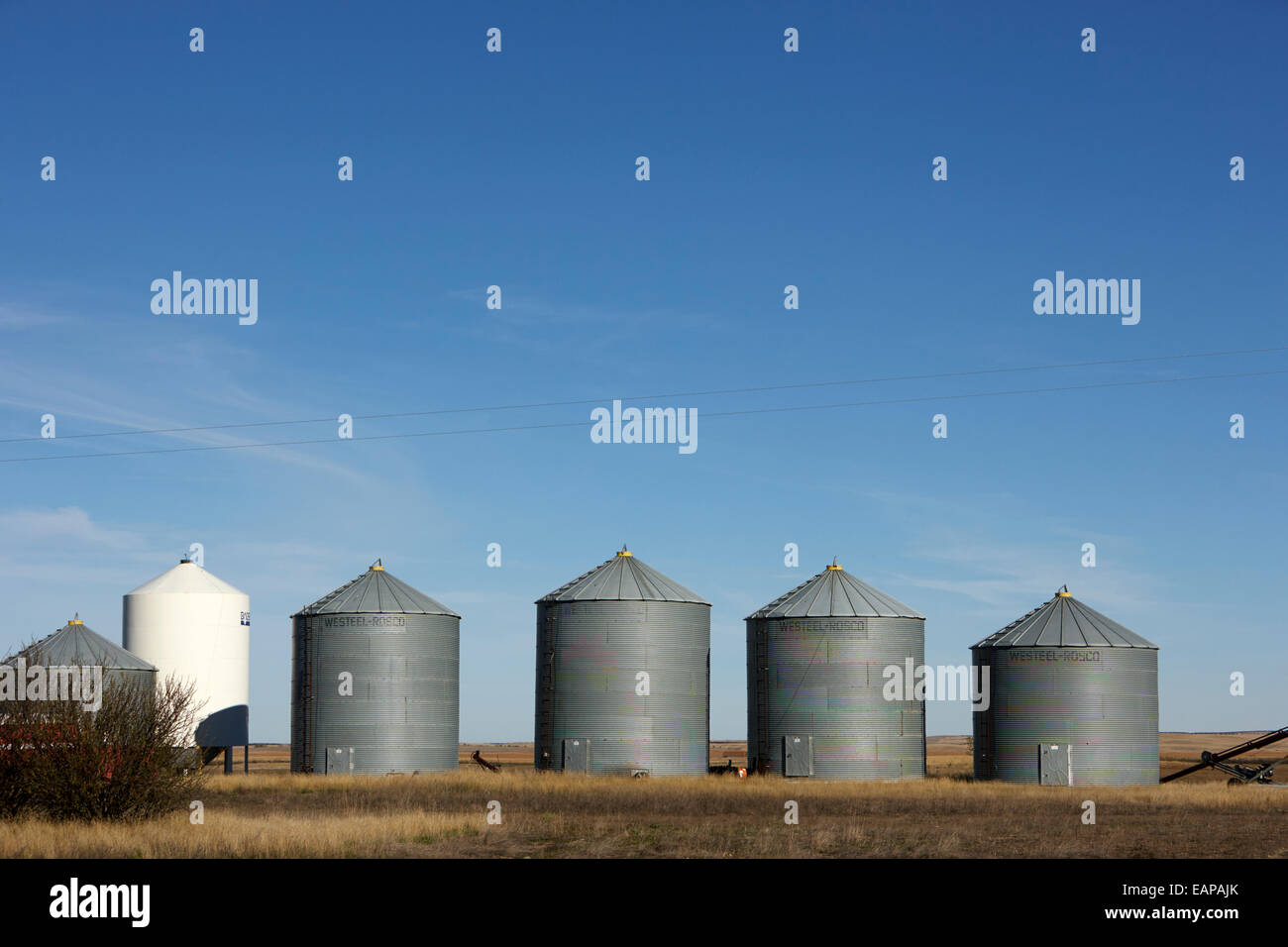 commercial grain storage bins and fertilizer bin on a farm Saskatchewan Canada Stock Photo