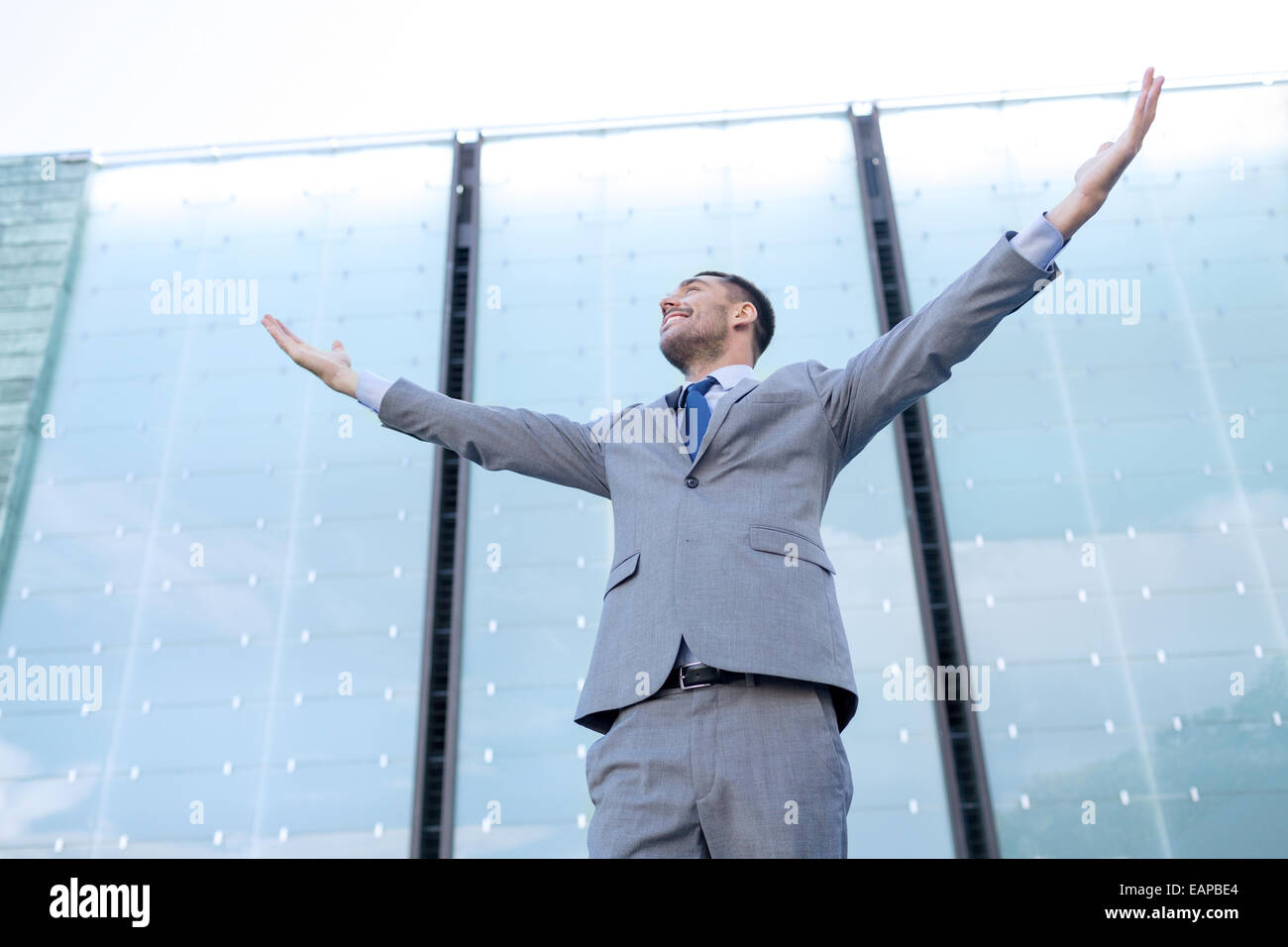 young smiling businessman over office building Stock Photo - Alamy