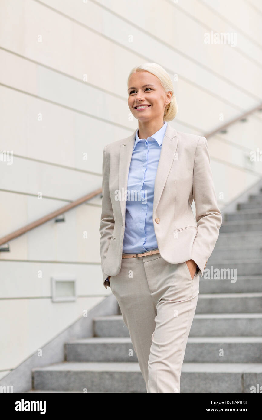 young smiling businesswoman walking down stairs Stock Photo