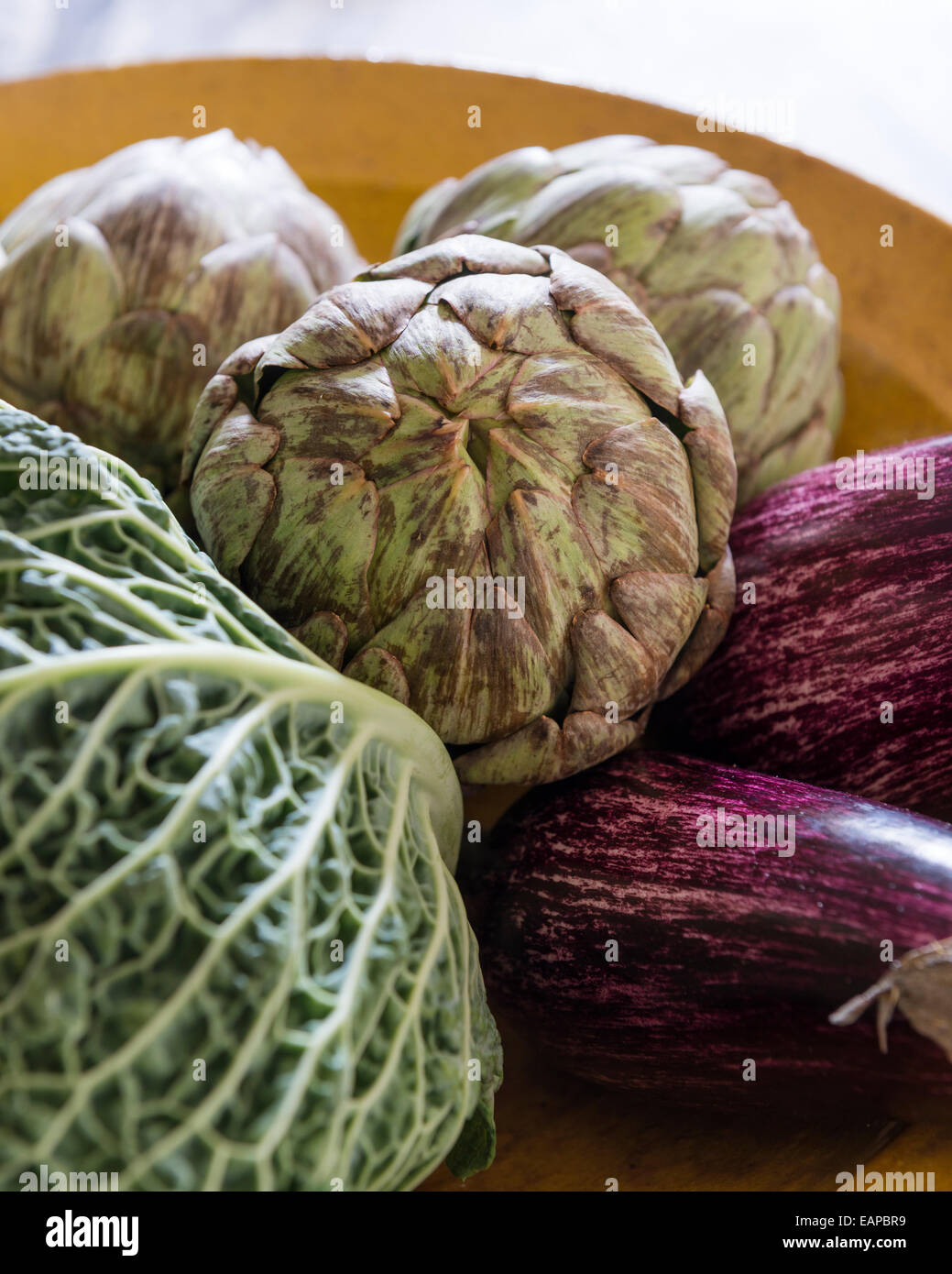Artichokes, cabbage and aubergines in ceramic dish Stock Photo