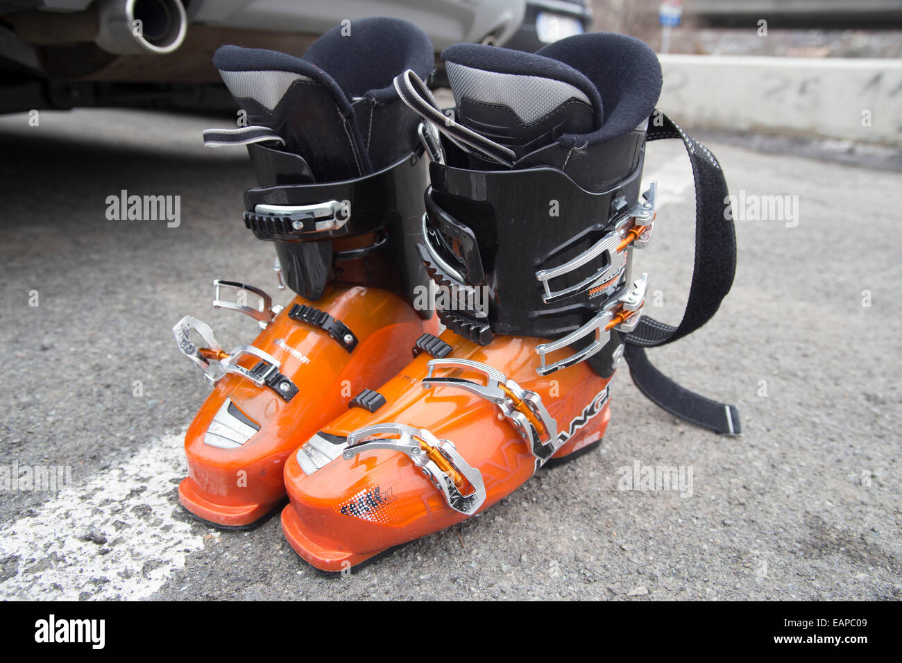 Orange ski boots in a car park Stock Photo