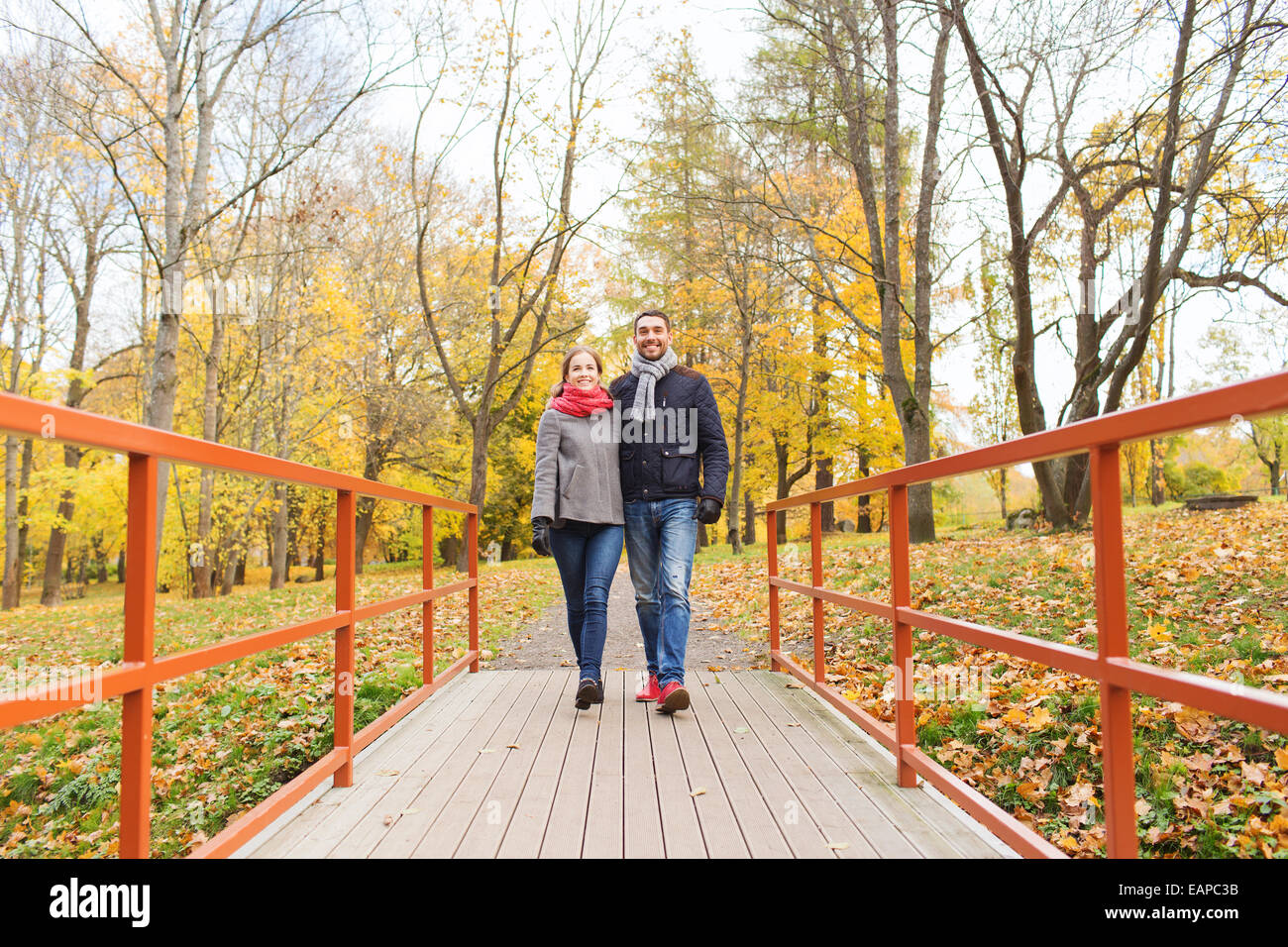 smiling couple hugging on bridge in autumn park Stock Photo - Alamy