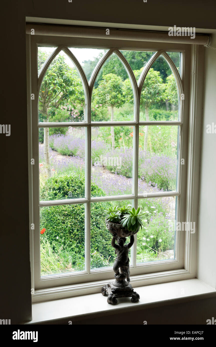 Small statue on ledge of Gothic style window Stock Photo