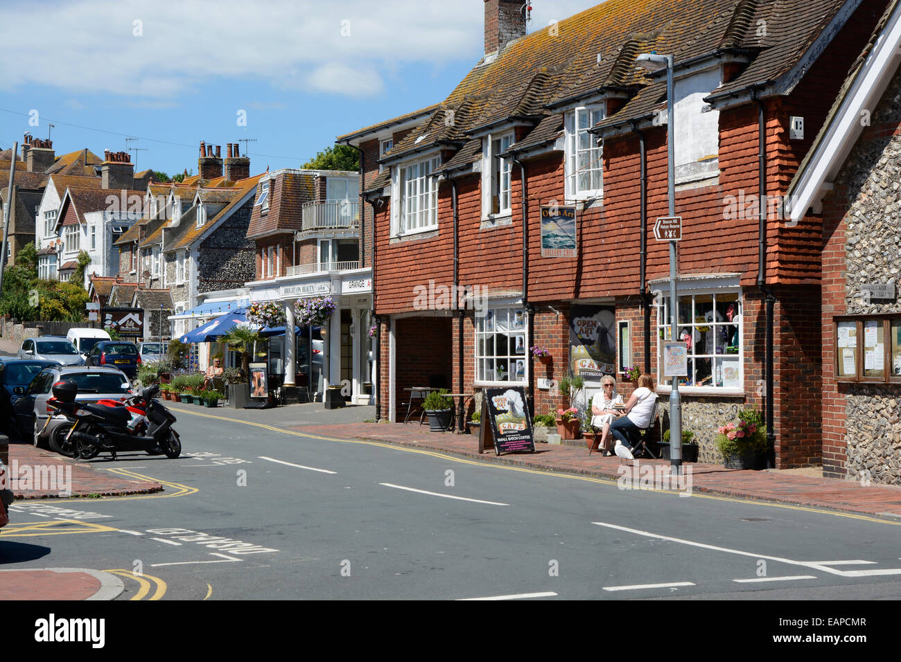 Houses, shops and cafes in the village of Rottingdean near Brighton. East Sussex. England With people seated outside. Stock Photo
