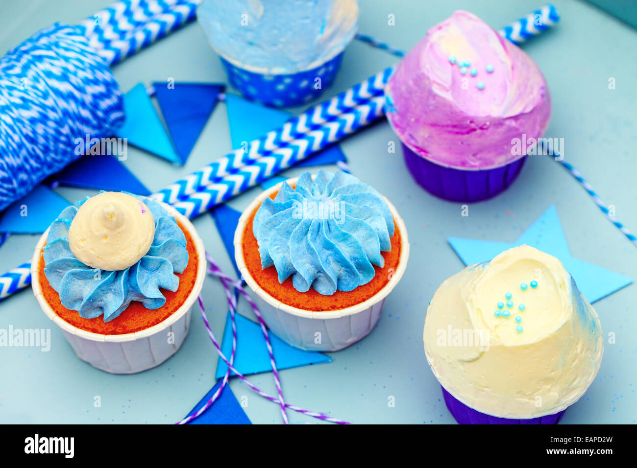 Delicious sweet buffet with cupcakes on blue background Stock Photo