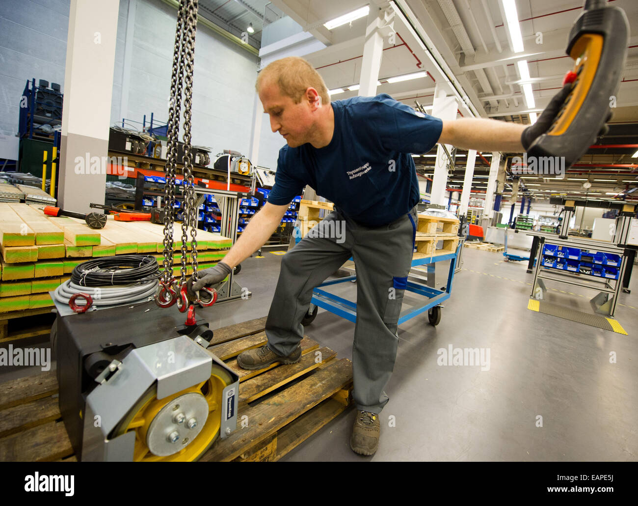 A Thyssenkrupp Elevator Factory Employee Lifts A Motor With A Crane Stock Photo Alamy