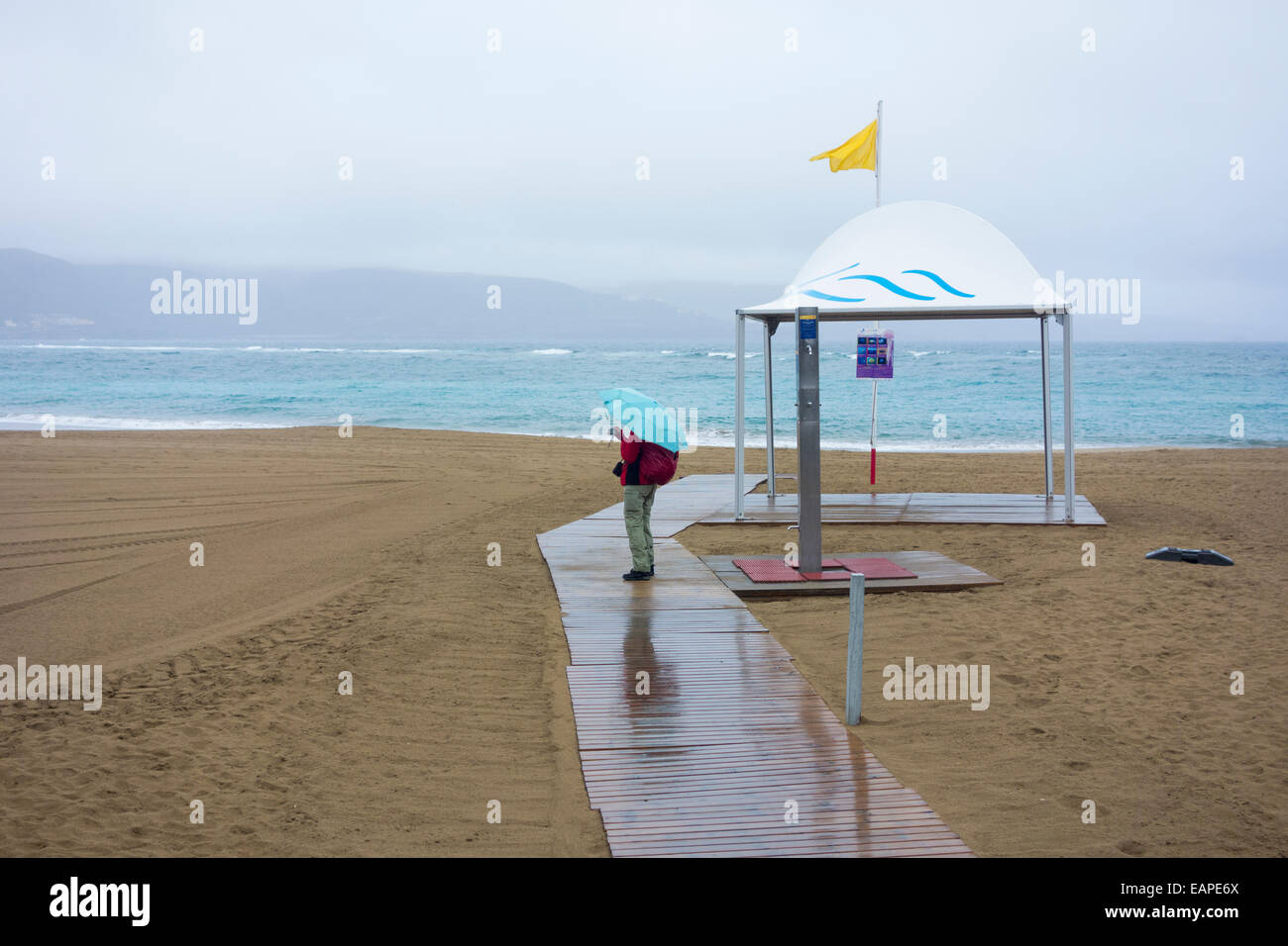 Las Palmas, Gran Canaria, Canary Islands, Spain. 19th November, 2014.  Weather: Lone tourist on the usually packed Las Canteras beach in Las Palmas,  the capital of Gran Canaria, as heavy rain sweeps