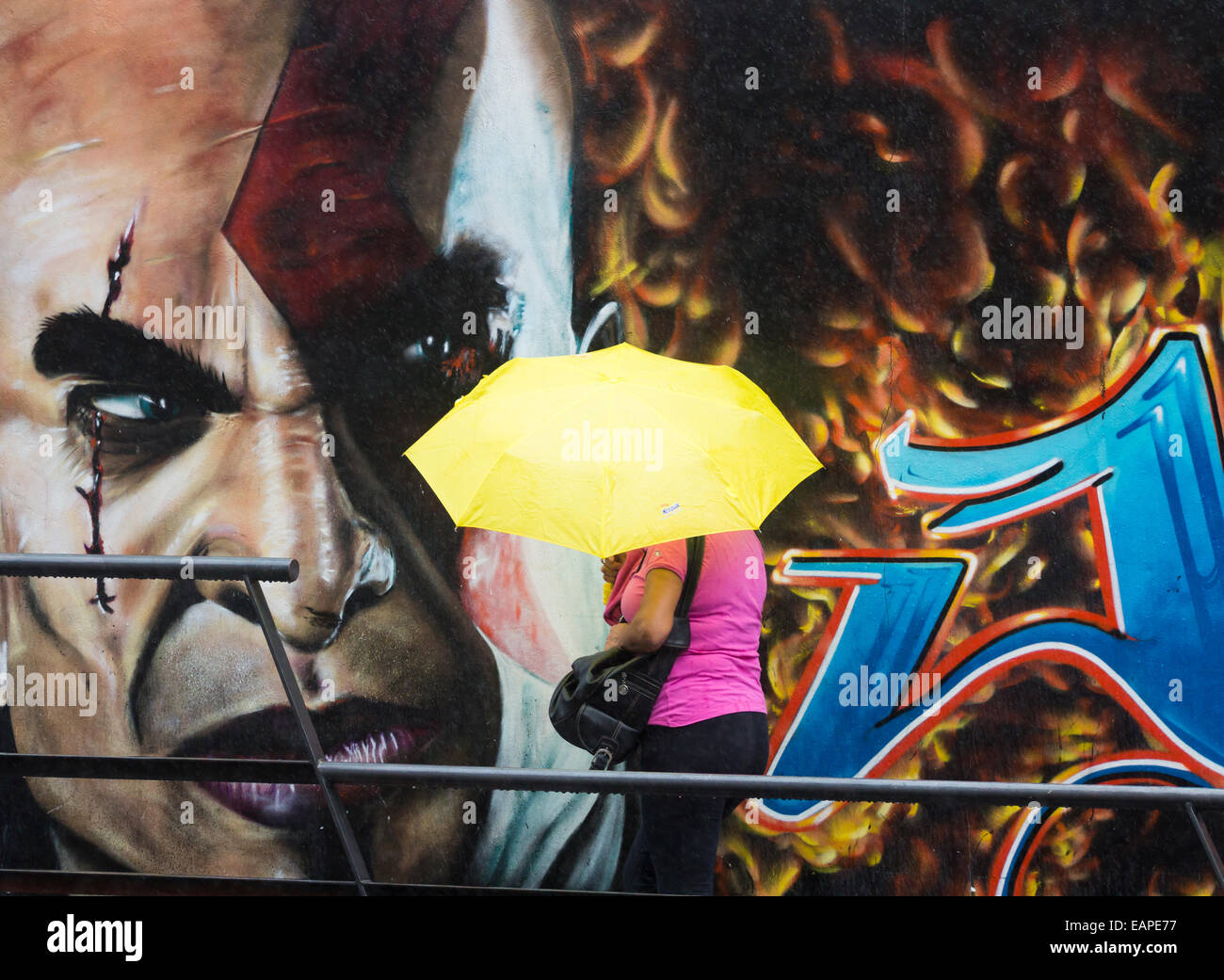 Woman with umbrella walking past graffiti Stock Photo Alamy
