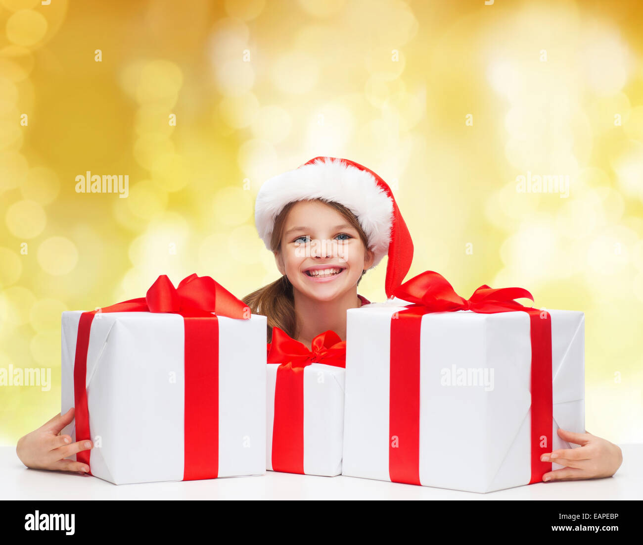 smiling girl in santa helper hat with gift boxes Stock Photo - Alamy