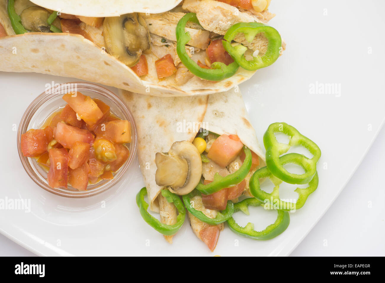 Mexican fajitas, chicken and vegetables, with tomatoes Extra. over white background Stock Photo