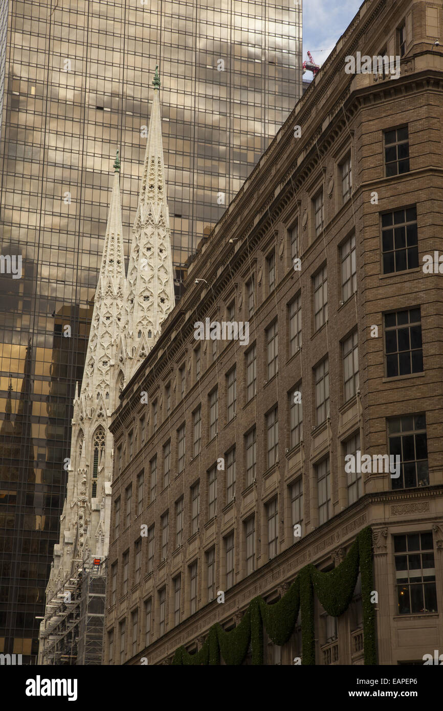 The trwin steeples of St. Patrick's Cathedral stand out amidst the eclectic architecture along 5th Avenue in NYC. Stock Photo