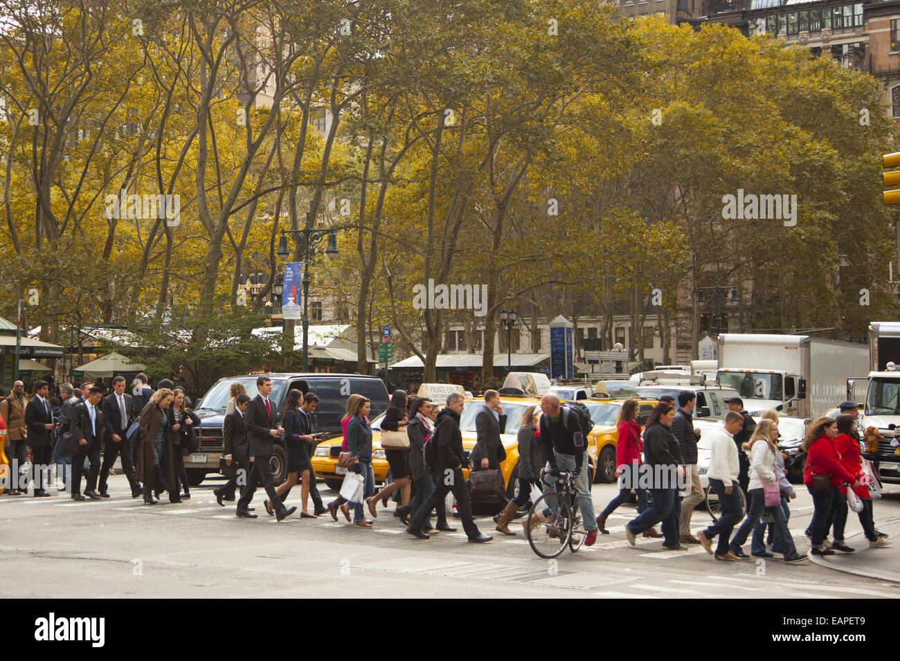 Pedestrians stream across 6th Avenue & 42nd St. at Bryant Park. NYC. Stock Photo
