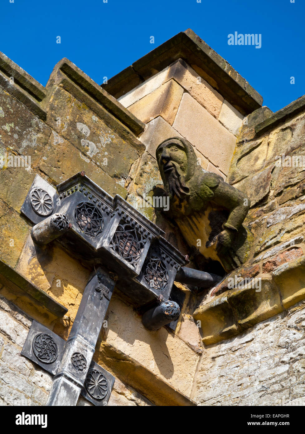 Gargoyle and decorative lead pipe on the exterior of Haddon Hall a medieval house near Bakewell in Derbyshire Peak District UK Stock Photo