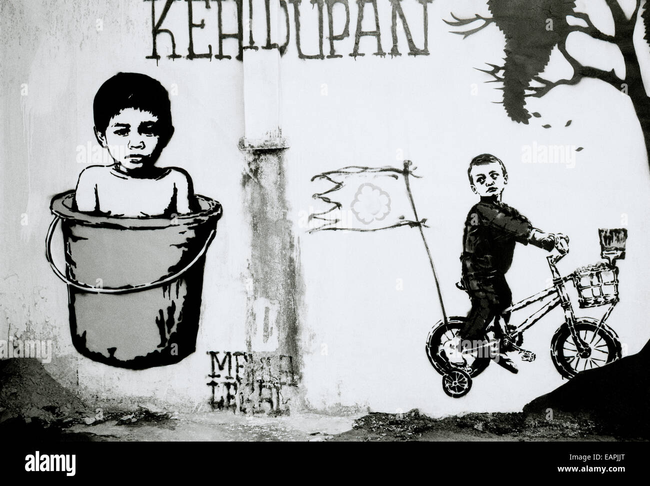 Banksy style surreal urban street graffiti art in Yogyakarta in Java in Indonesia in Southeast Asia Far East. Baby Child Childhood Travel Conceptual Stock Photo